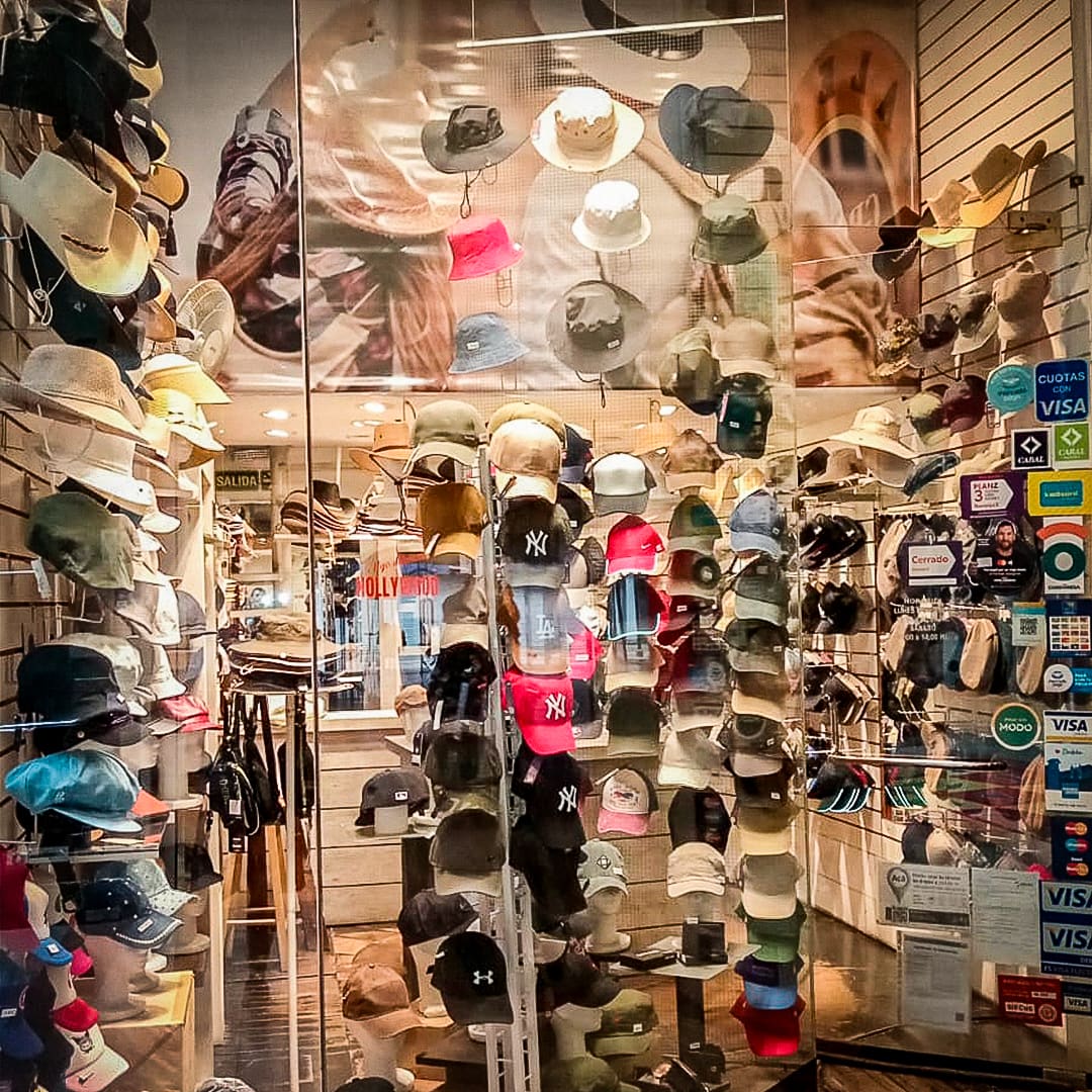 Vidriera iluminada con gorras y sombreros